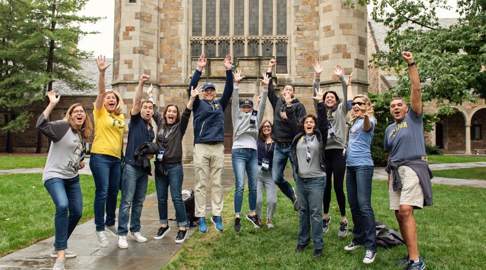 Alumni jumping in celebration of reunion on the quad