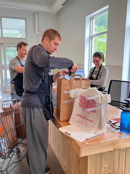 A Michigan Law alumni volunteers to bag groceries.