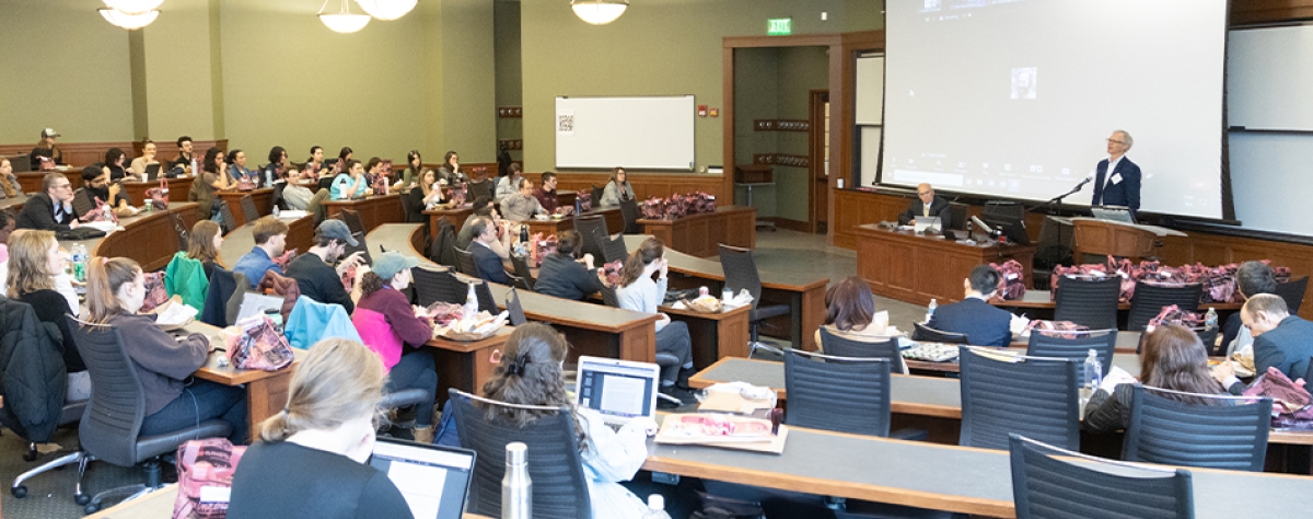 Two people lecturing to a packed auditorium at the university of Michigan law school.