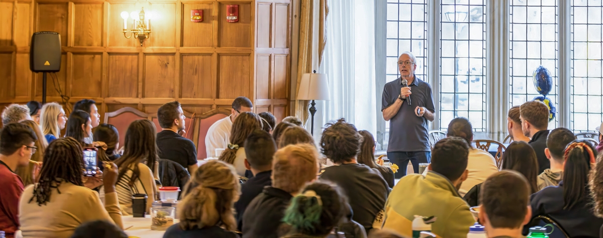 Professor Dave Moran speaks in front of a large group.