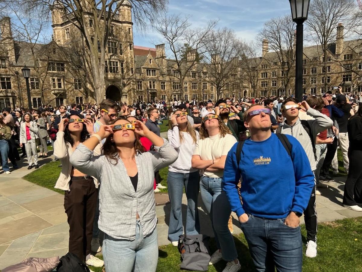 Students from the PAC all looking up at the solar eclipse with their eclipse glasses on.