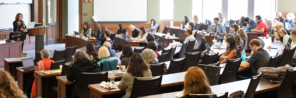 A speaker at a podium addresses a full classroom of attendees at the recent Michigan Law Gender Apartheid Conference.