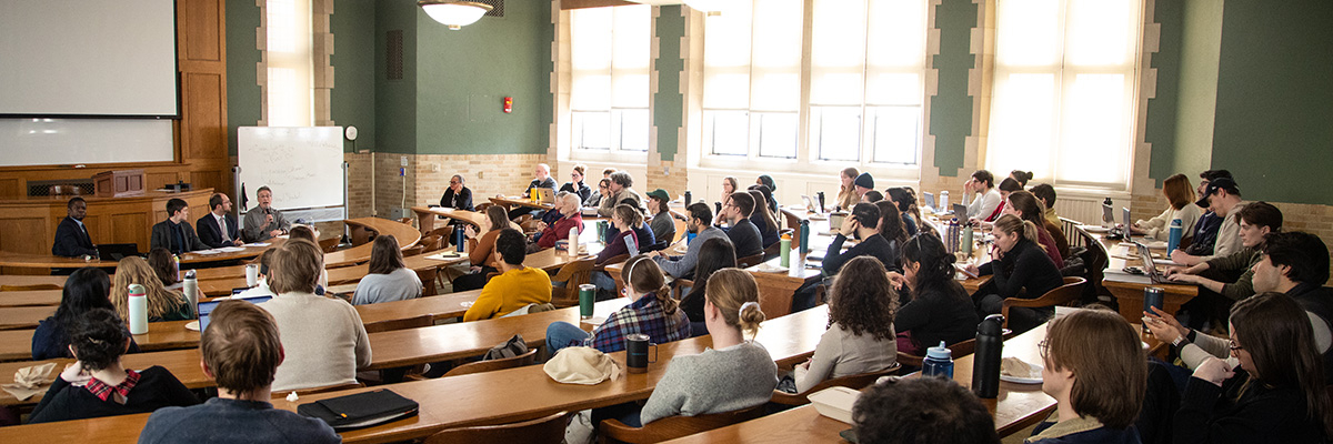 A classroom full of participants listen while Michigan Law professors Ekow Yankah, Paulina Arnold, Noah Kazis, Evan Caminker speak at the Immigrant Enforcement Panel.