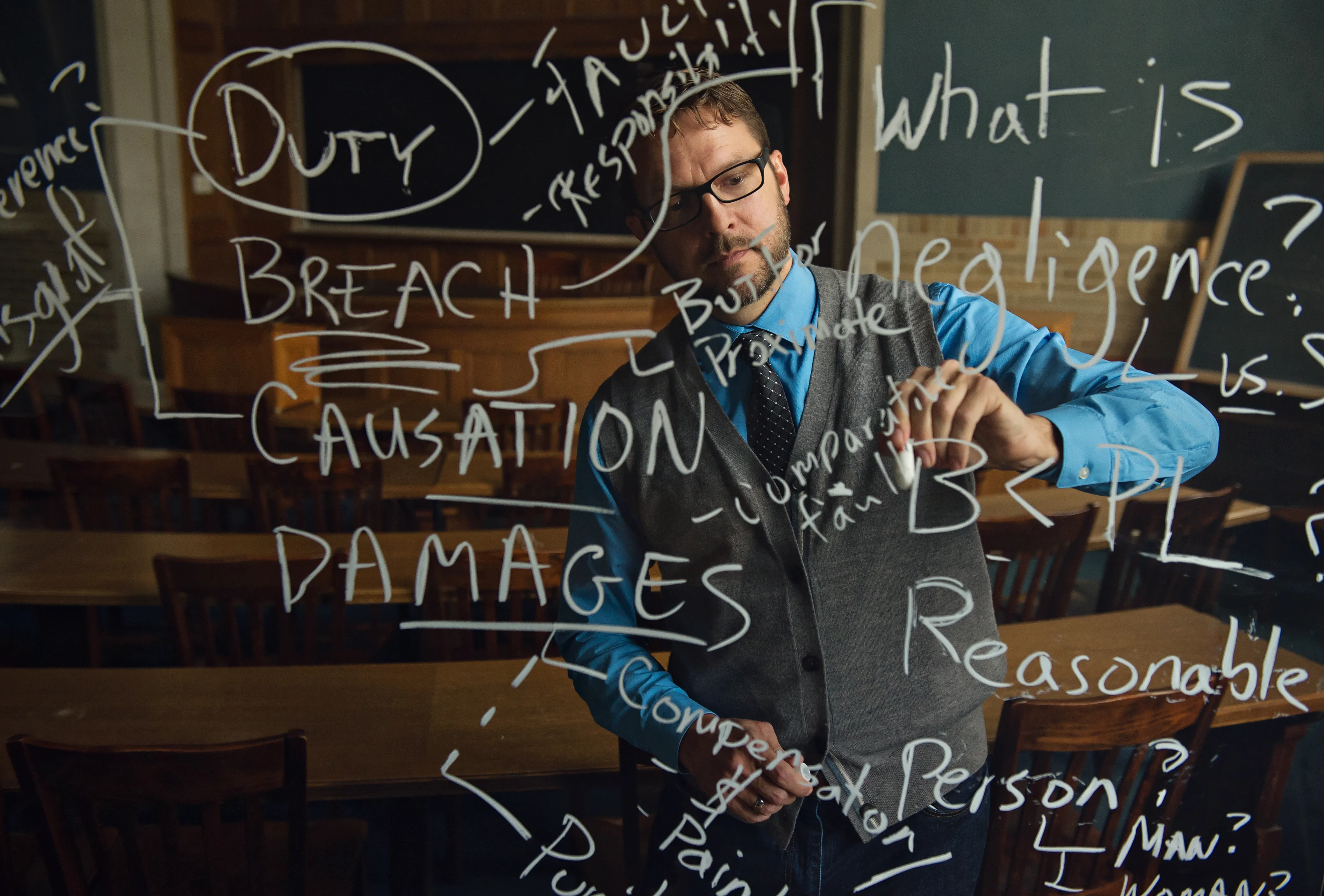 Kyle Logue taking notes on a clear board in a classroom