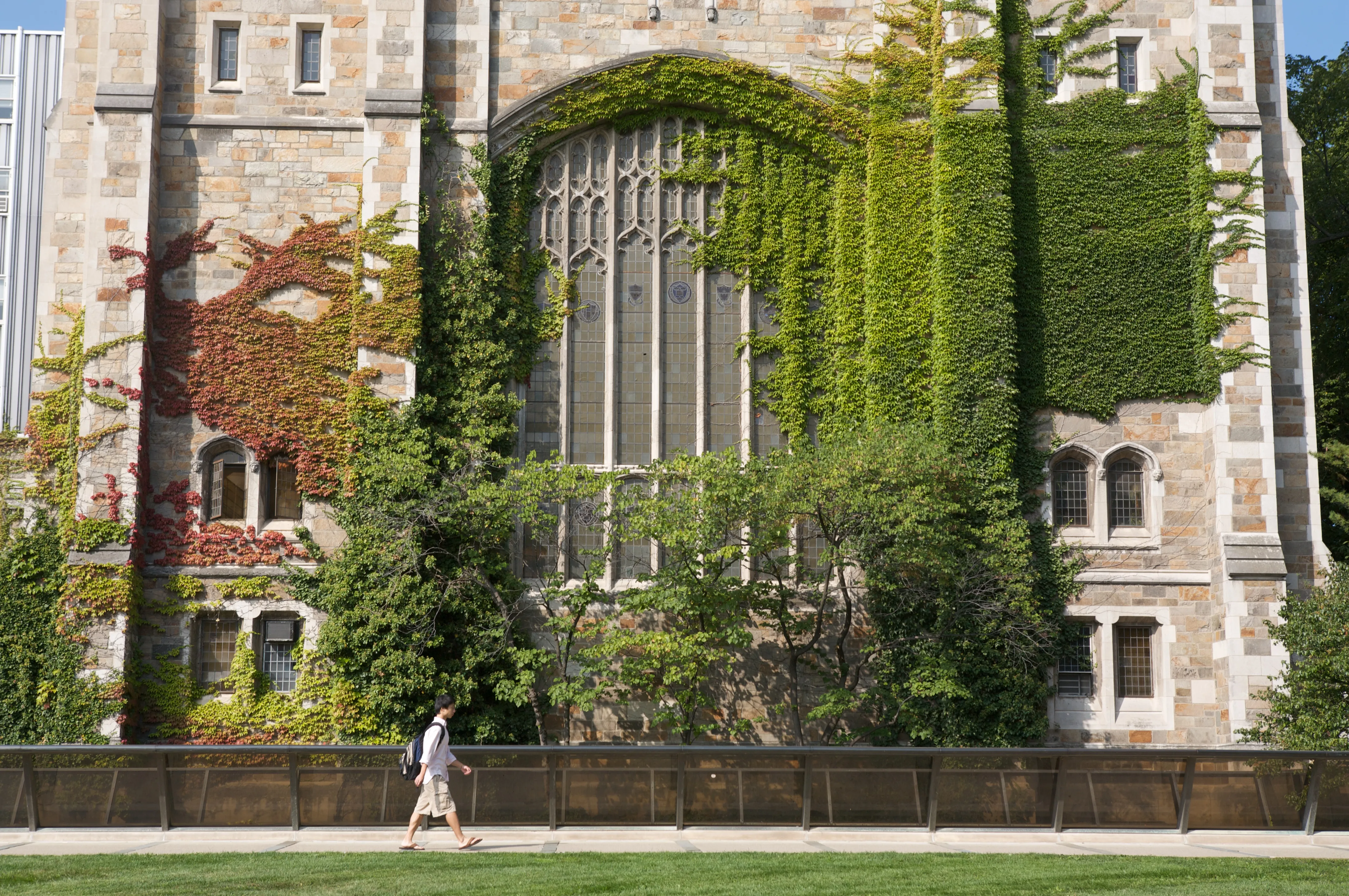 Person walking across the sidewalk in front the Reading Room