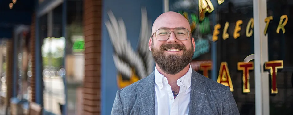 Professor Aaron Perzanowski with a tatto shop in the background