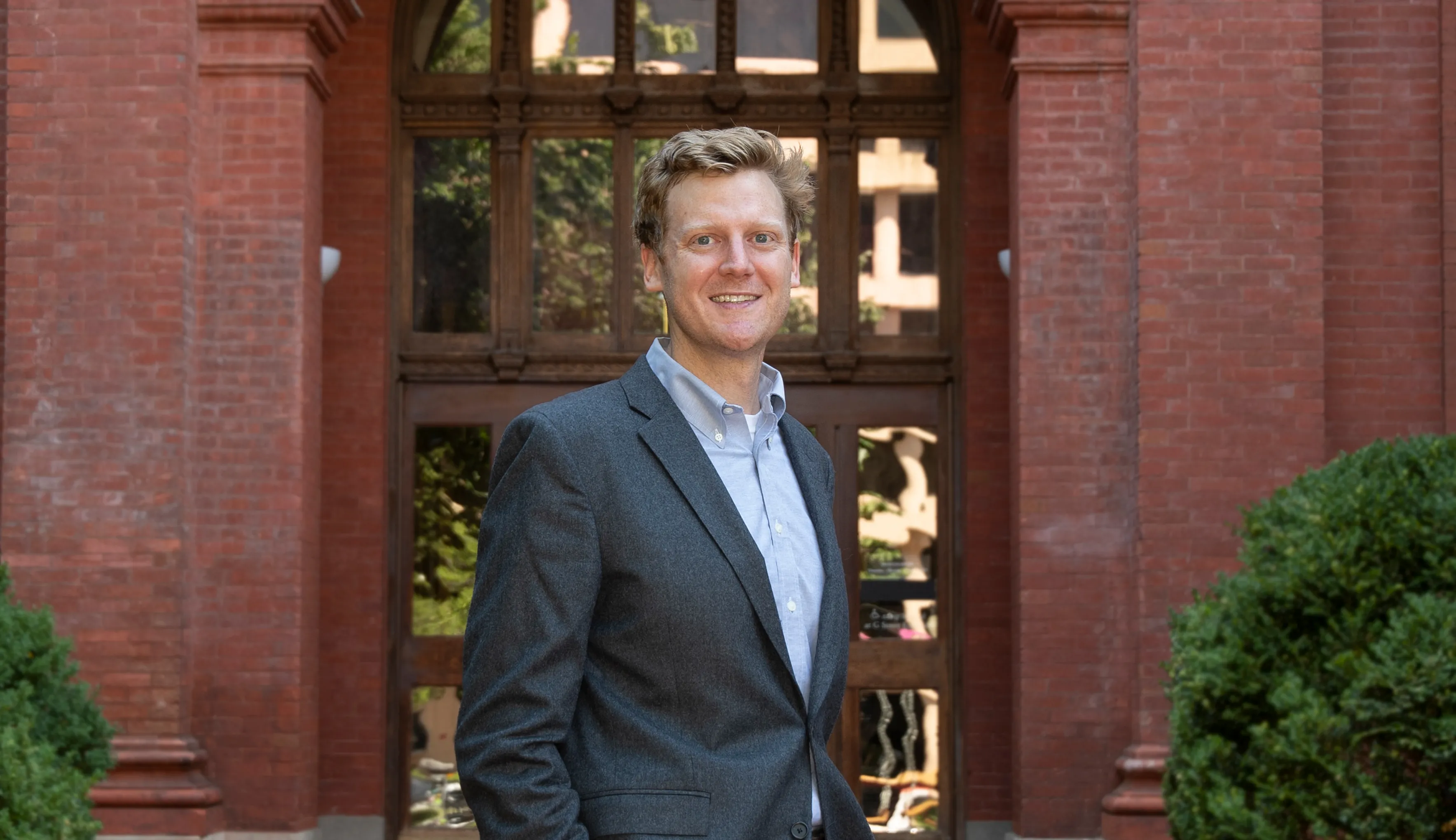 Professor Steven Schaus standing in front a red brick building