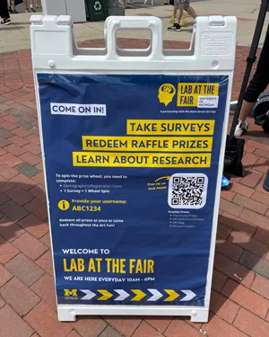 A sandwich board asking people to take surveys that will contribute to legal research.