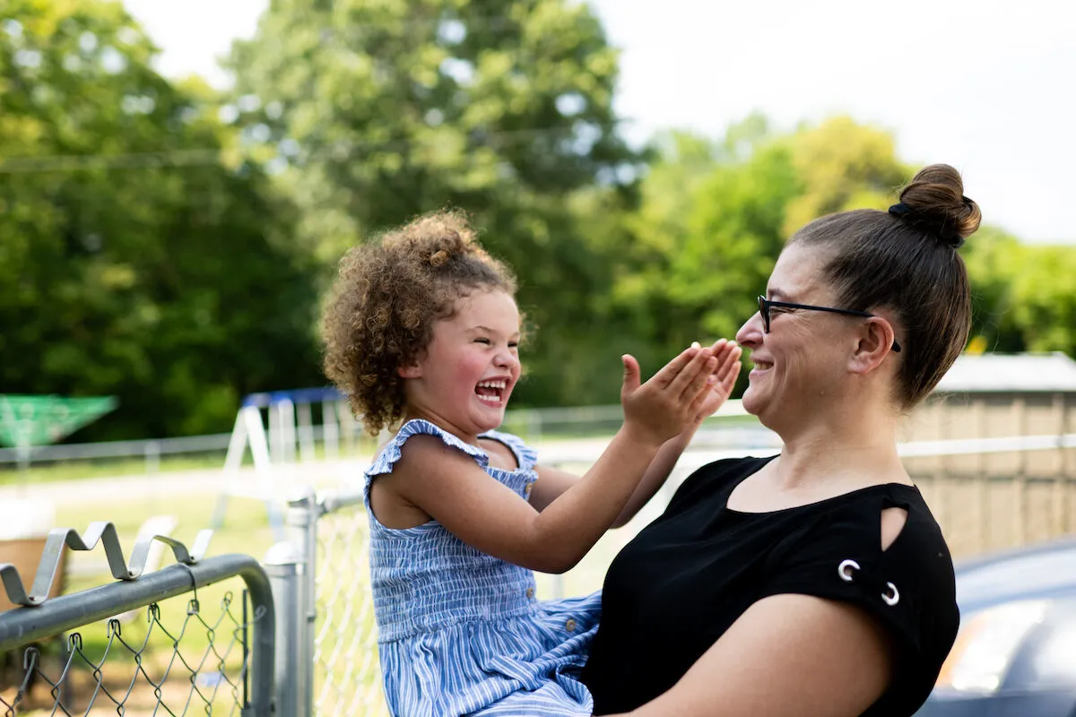 A mother smiles at the child in her arms.