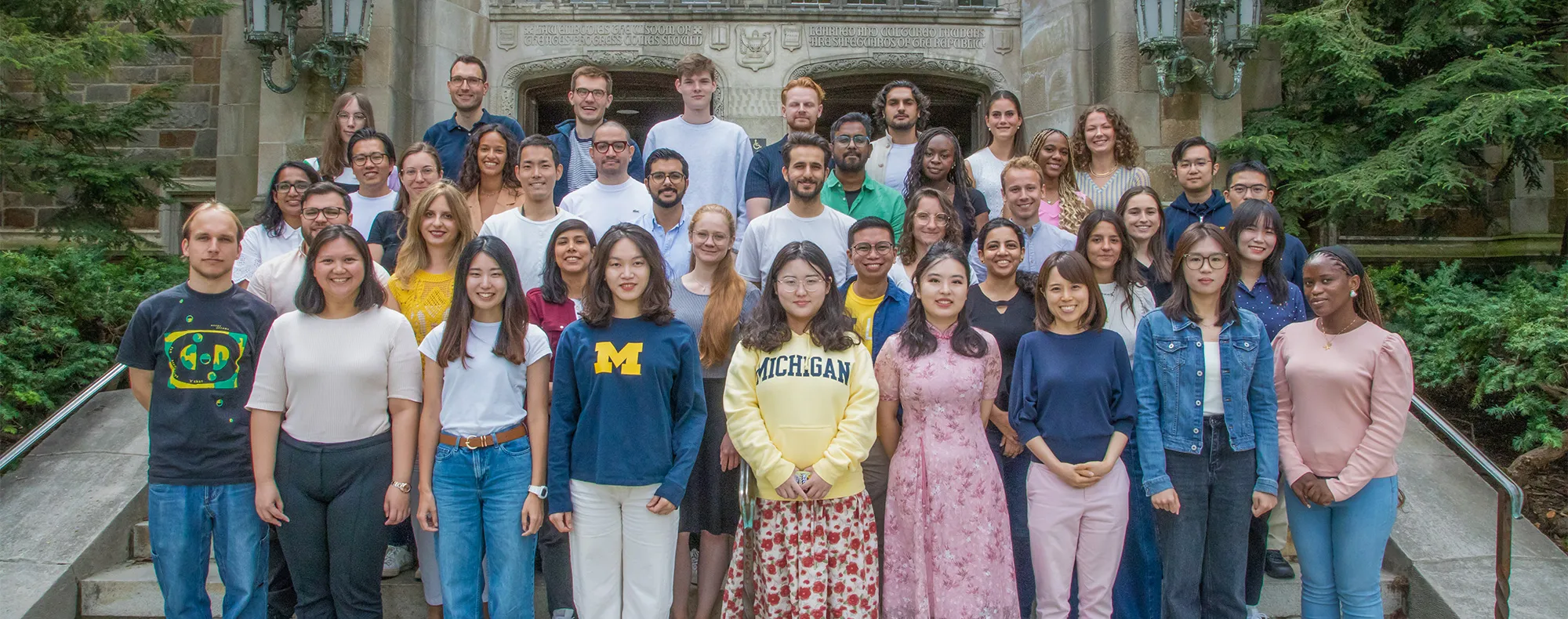 A group of LLM students pose for a portrait outside the Reading Room.