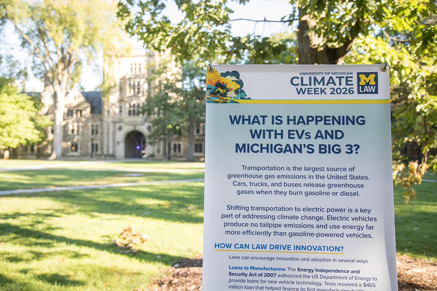 An exhibit about EVs with a Law School building in the background.