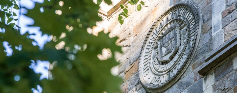 Exterior architectural view of the Reading Room pillar with University of Michigan crest in stone