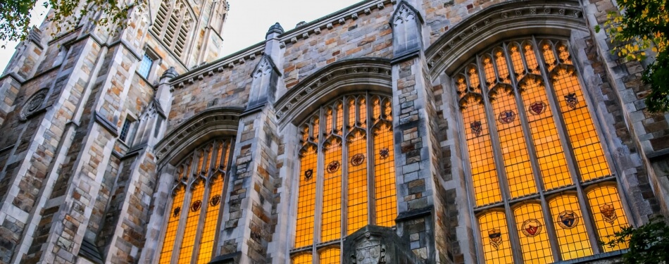 Exterior view of the Michigan Law Reading Room illuminated windows during dusk