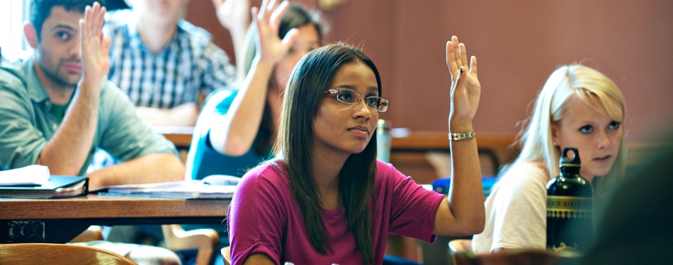 Students in raising hand in the classroom.