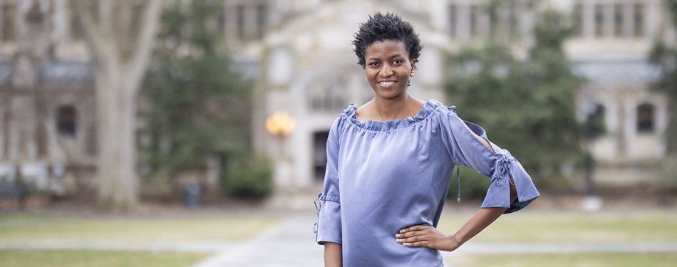 Abimola Adekoya stands in the Michigan Law Quad with her hand on her hip.