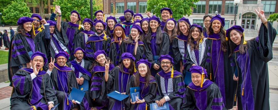 A group of Michigan Law Graduates pose for a graduation photo at the University of Michigan Diag.