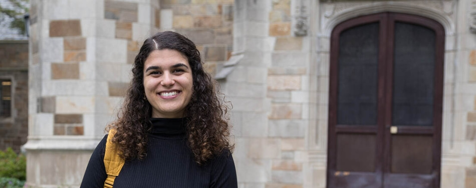 Fernanda Lopes De Alcantara Gil stands in front of an exterior door at Michigan Law.