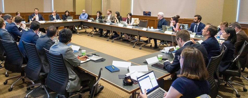 Participants gather around a table at a conference.