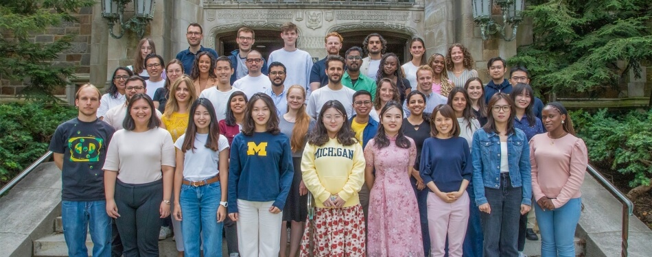 A group of LLM students pose for a portrait outside the Reading Room.