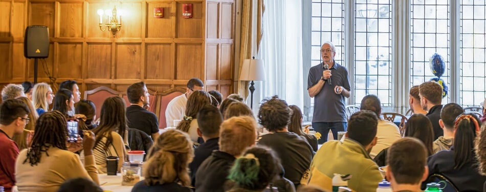 Professor Dave Moran speaks in front of a large group.