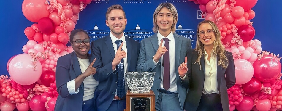 The Michigan Law Mock Trial Team from left to right, Joclyn Hutchison, Nat Jordan, Brian Tang, and Lauren Smith celebrate their win in front of their Capitol City Challenge (CCC) Mock Trial Competition trophy.