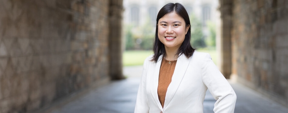 Michigan Law professor Belisa Pang stands under a Lawyers Club archway.