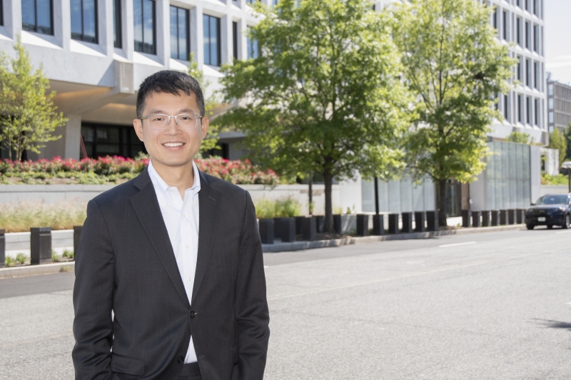 Professor Jeffery Zhang standing in front of the Federal Reserve building