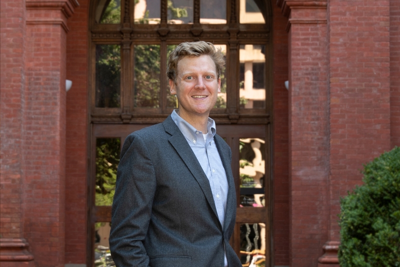 Professor Steven Schaus standing in front a red brick building