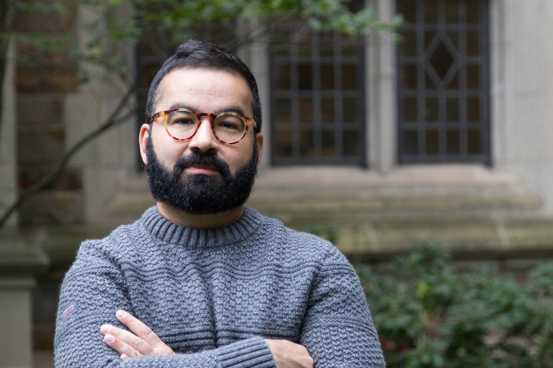 Daniel Athias stands arms folded in the Michigan Law quad.