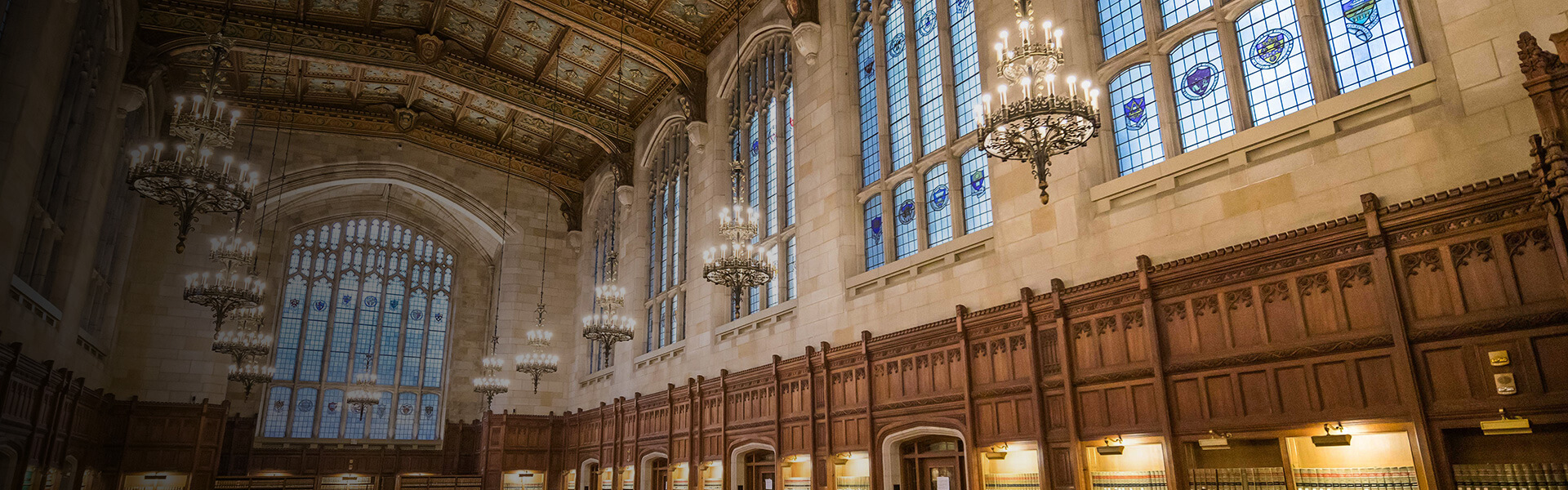 Interior of the Michigan Law Reading Room featuring the ornate lights and ceiling ornamentation.