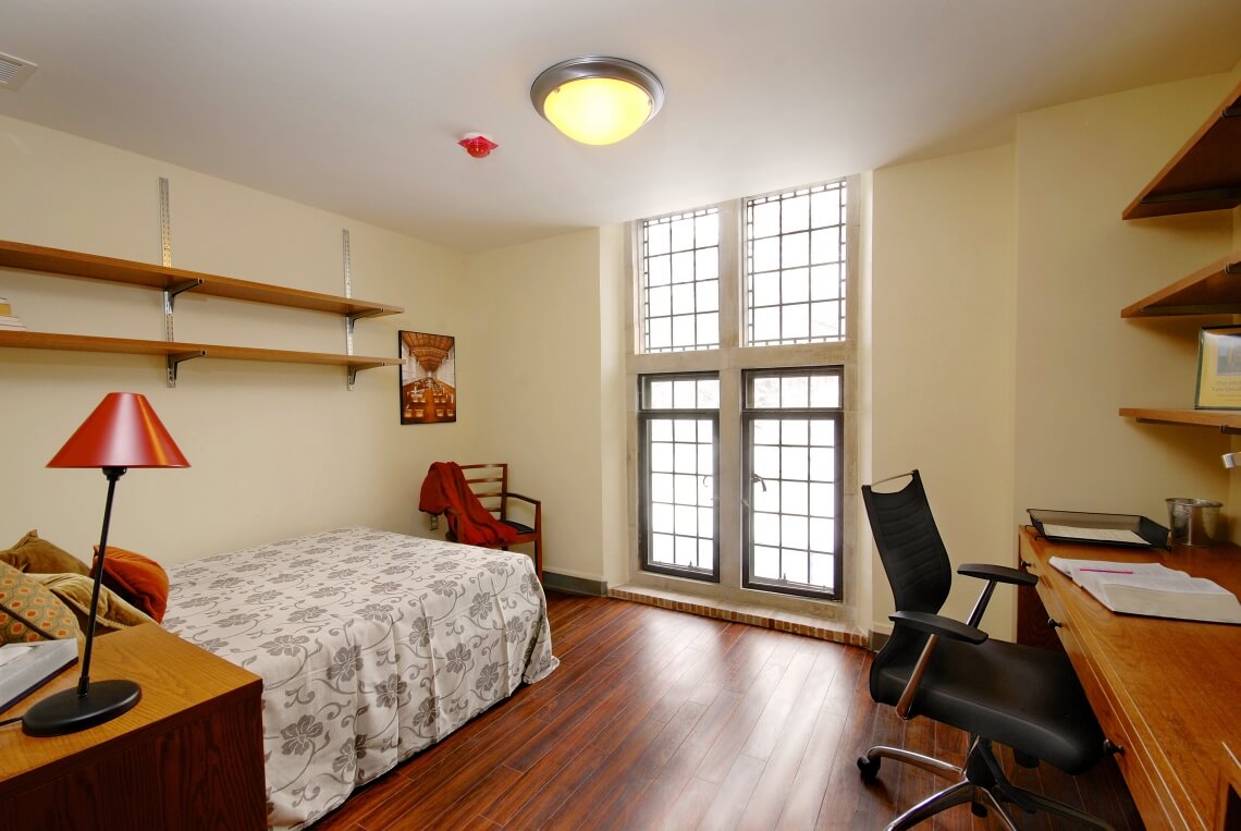 Student rooms have storage shelves and built-in desks. Beds are full size and extra long.