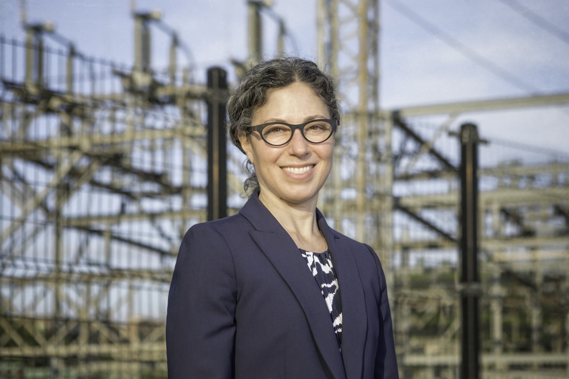 Professor Alexandra Klass standing in front of a hydroelectric facility