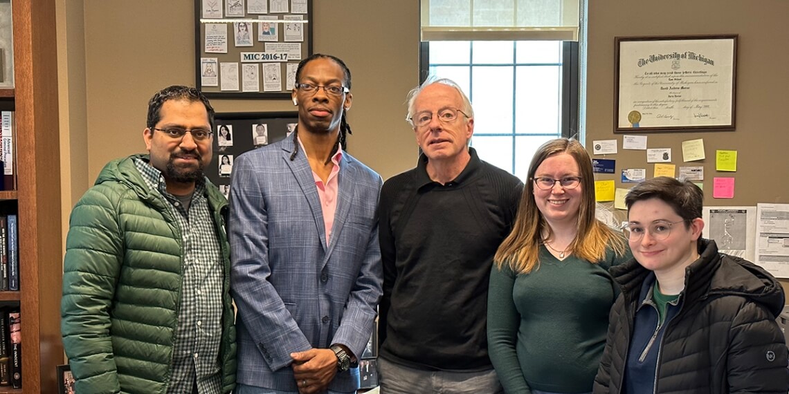 Donyelle Woods (center, holding his grandson) celebrates his newfound freedom with a few of the people who worked on his case at the Michigan Innocence Clinic: (from left) 3L Kate Thompson; Imran Syed, ’11, the clinic’s co-director; and Jake Aronson and Sam Winick, both 2Ls. Syed first began working on Woods’s case as a student-attorney just after the clinic opened in 2009.