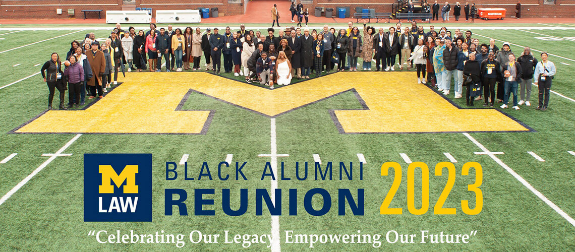 Attendees of the Michigan Law Black Alumni Reunion 2023 pose for a group portrait on the field of Michigan Stadium.