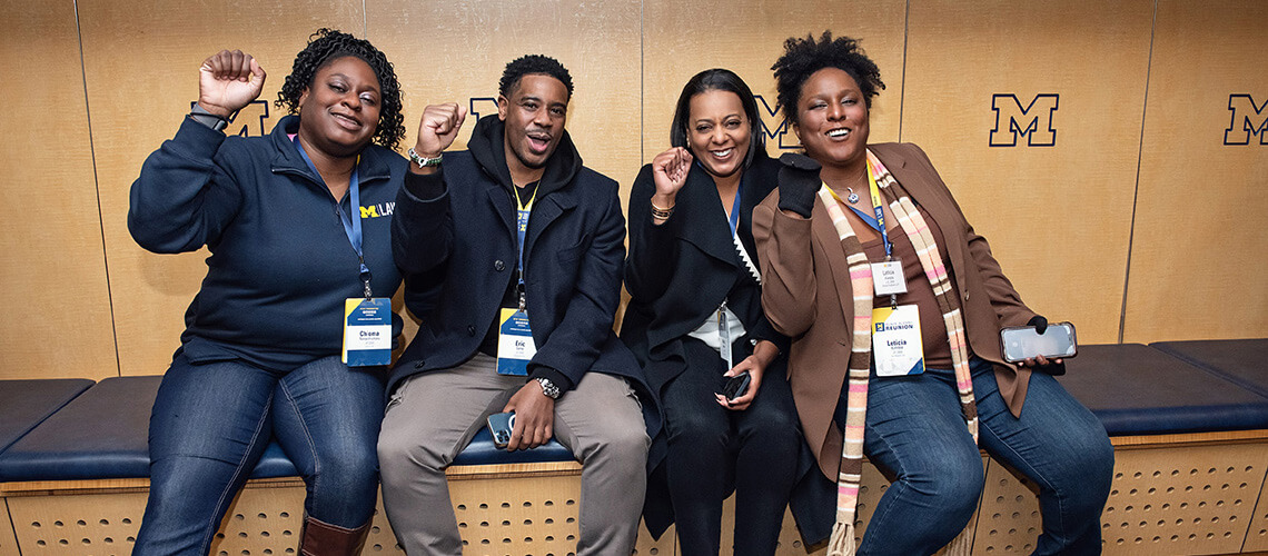 Chioma Nwachukwu, Eric Lane, Leticia Kimble, and fellow alumni cheer in the Michigan Stadium locker rooms.