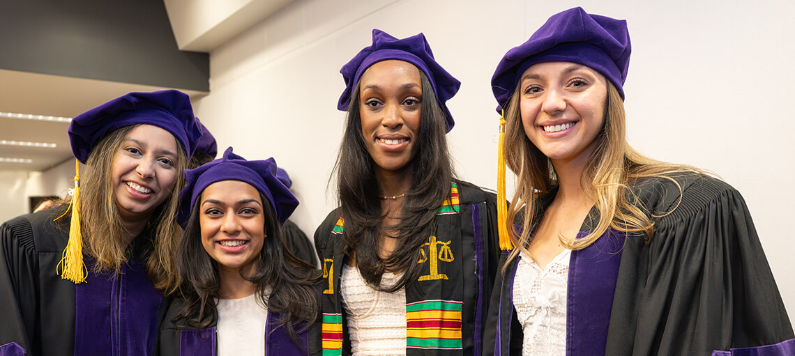 Four Michigan Law students smile together.