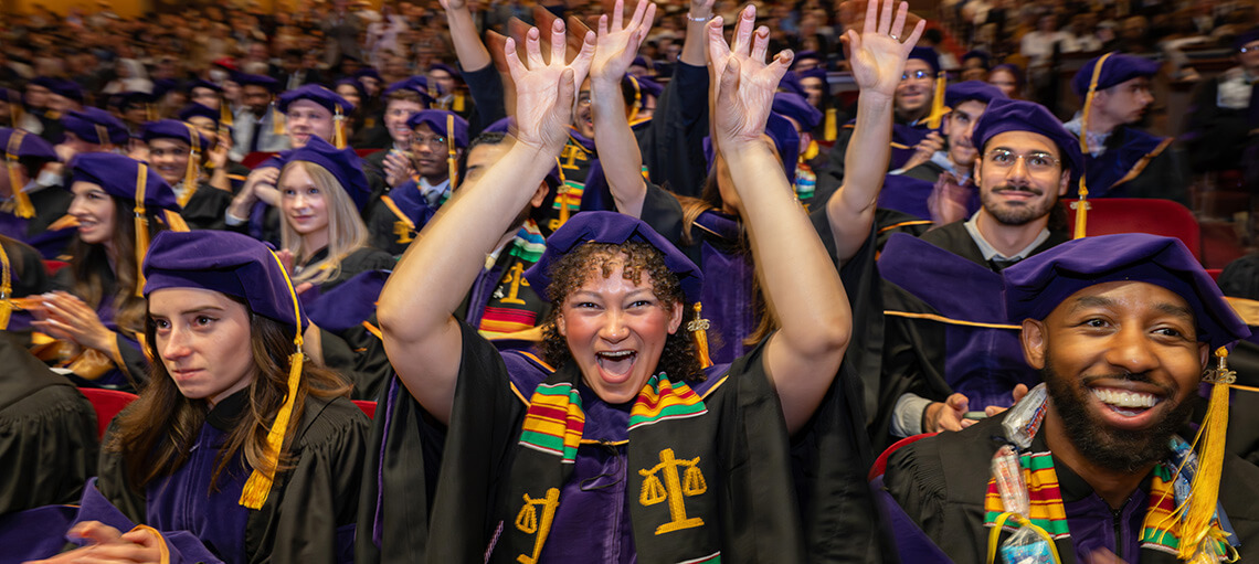 Michigan Law students cheering with their hands in the air.