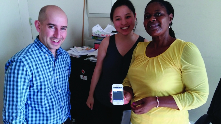 Katie Joh, '17, stands with her South Africa externship colleagues, one of whom shows an iPhone app.