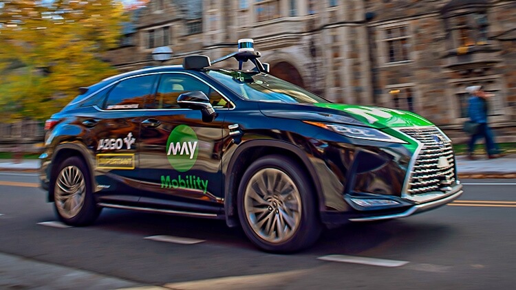 Autonomously driven car passing in front of Michigan Law buildings.
