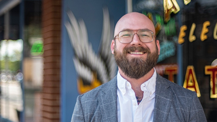 Professor Aaron Perzanowski with a tatto shop in the background