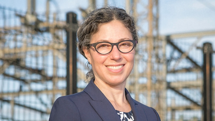 Professor Alexandra Klass standing in front of a hydroelectric facility