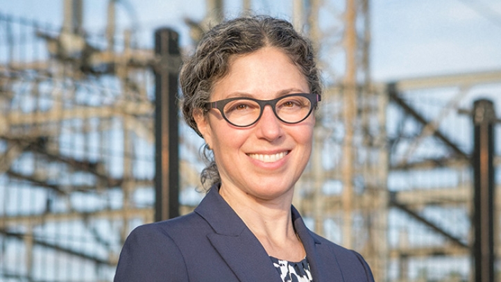 Professor Alexandra Klass standing in front of a hydroelectric facility 