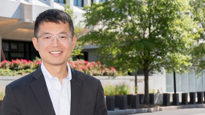 Professor Jeffery Zhang standing in front of the Federal Reserve building