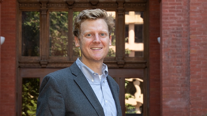 Professor Steven Schaus standing in front a red brick building