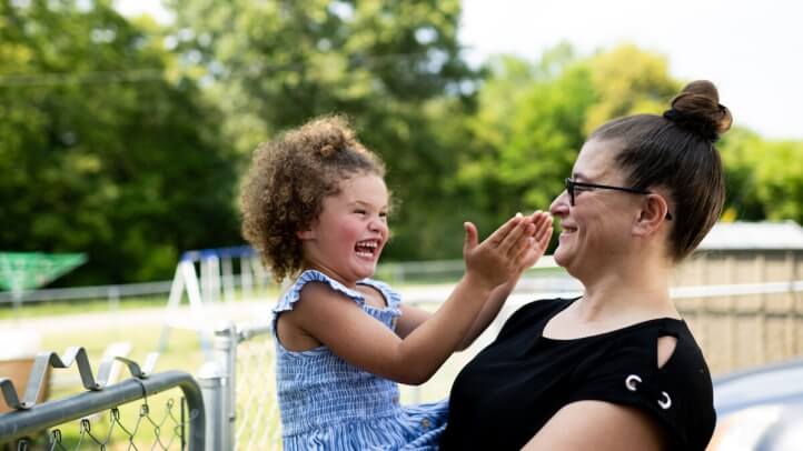 A mother smiles at the child in her arms.