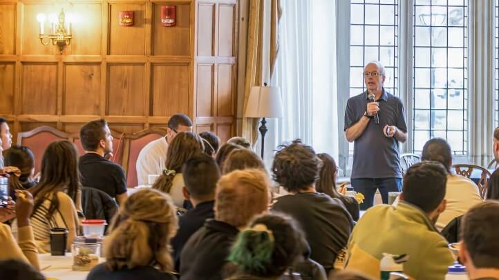 Professor Dave Moran speaks in front of a large group.