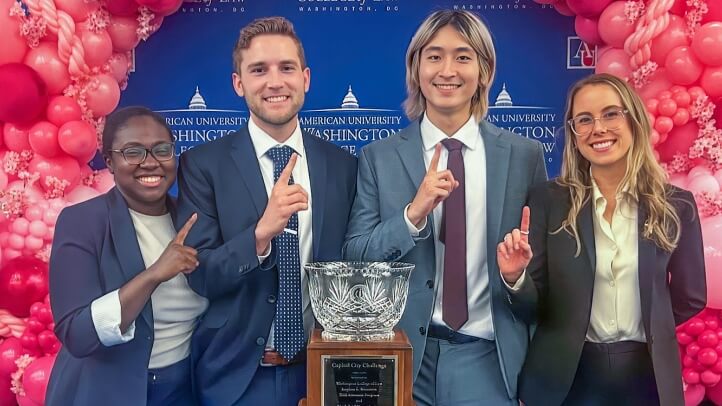 The Michigan Law Mock Trial Team from left to right, Joclyn Hutchison, Nat Jordan, Brian Tang, and Lauren Smith celebrate their win in front of their Capitol City Challenge (CCC) Mock Trial Competition trophy.