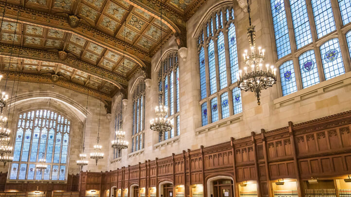 Interior of the Michigan Law Reading Room featuring the ornate lights and ceiling ornamentation.