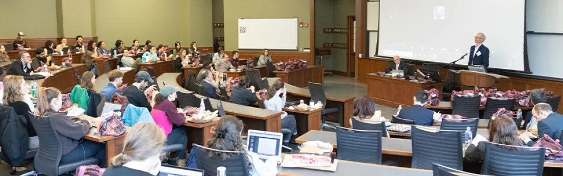 Two people lecturing to a packed auditorium at the university of Michigan law school.