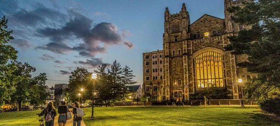 Students walking outside of the Michigan Law Reading Room at sunset.